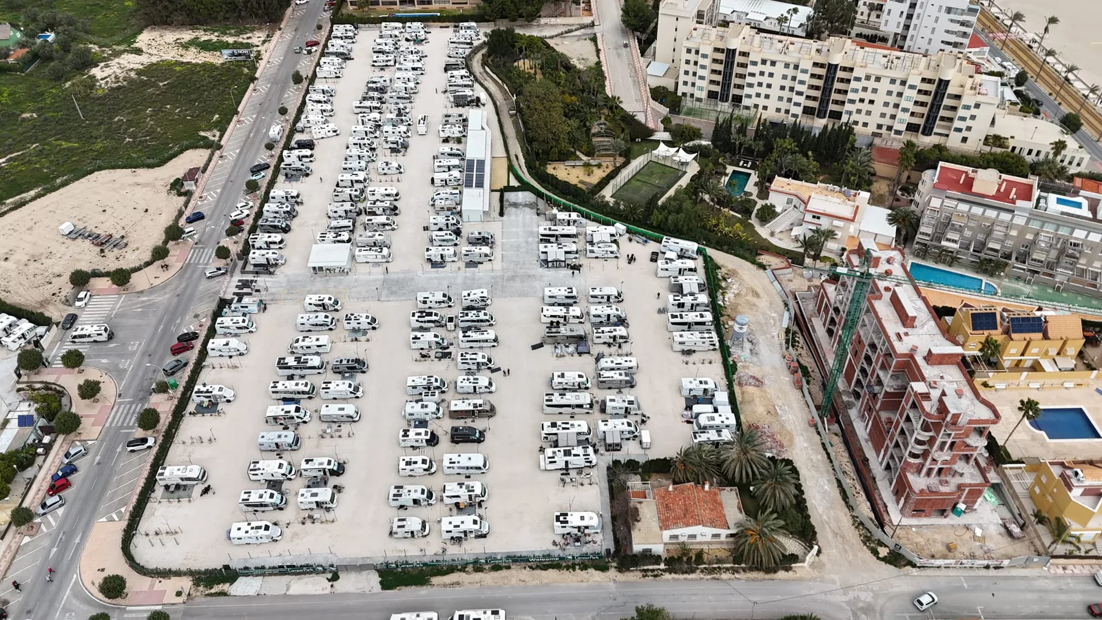 Vista aérea del recinto de Camper Park Alicante lleno de autocaravanas, con las banderolas de bienvenida