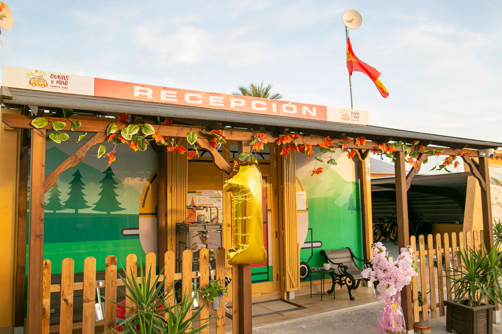 Edificio de recepción de Dunas y Mar Camper Park con su rótulo y la pérgola de acceso