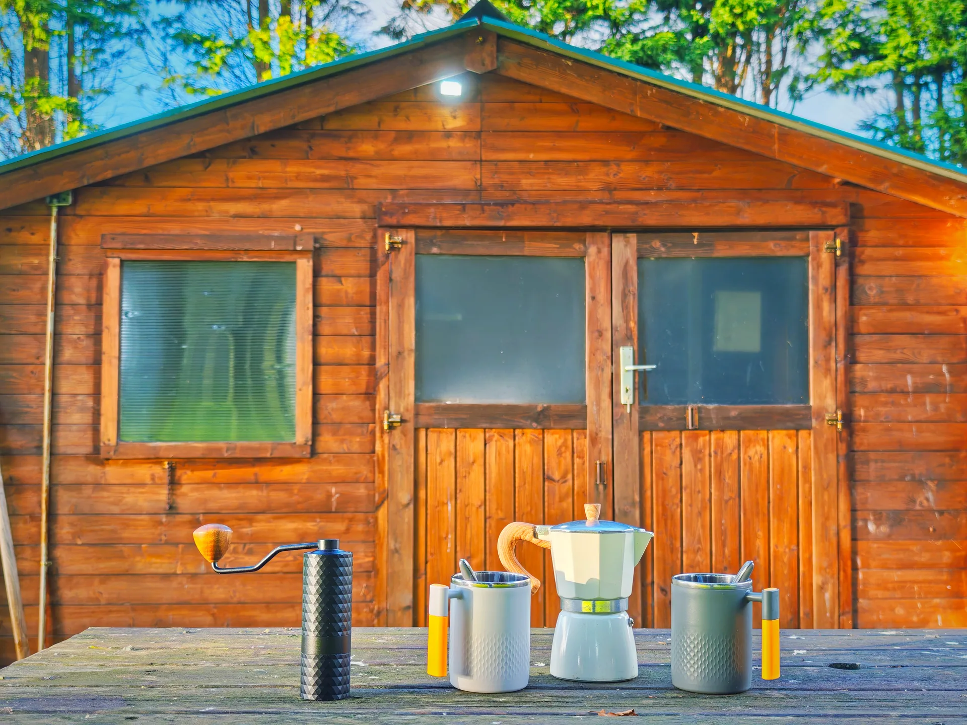 Caseta de madera del camping con utensilios sobre una mesa exterior.
