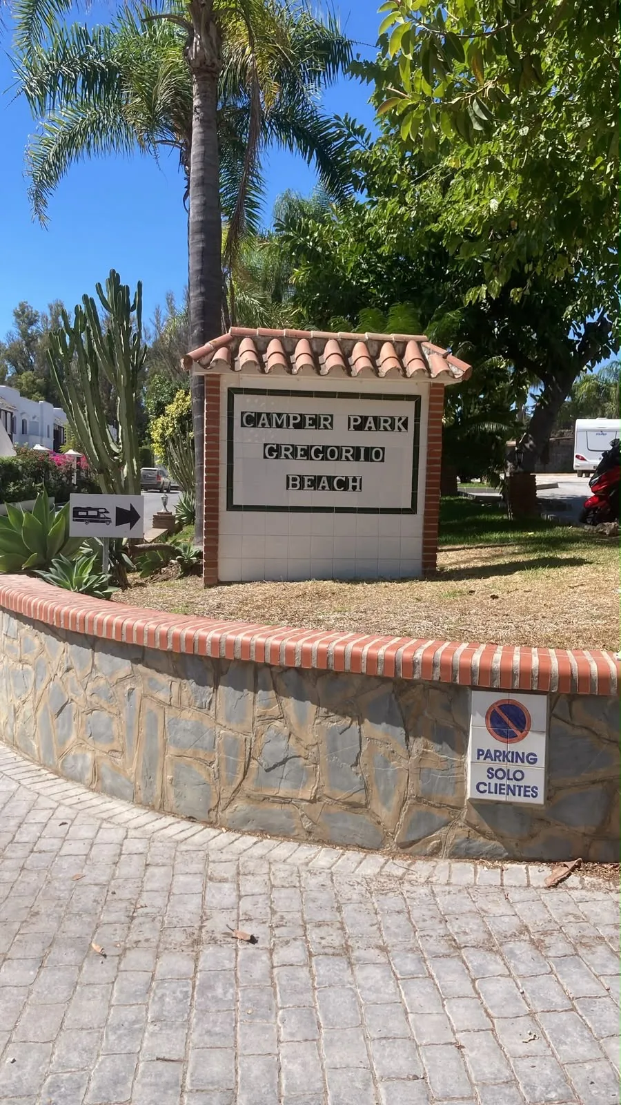 Entrada del Camper Park Gregorio Beach con señalización y zona ajardinada.