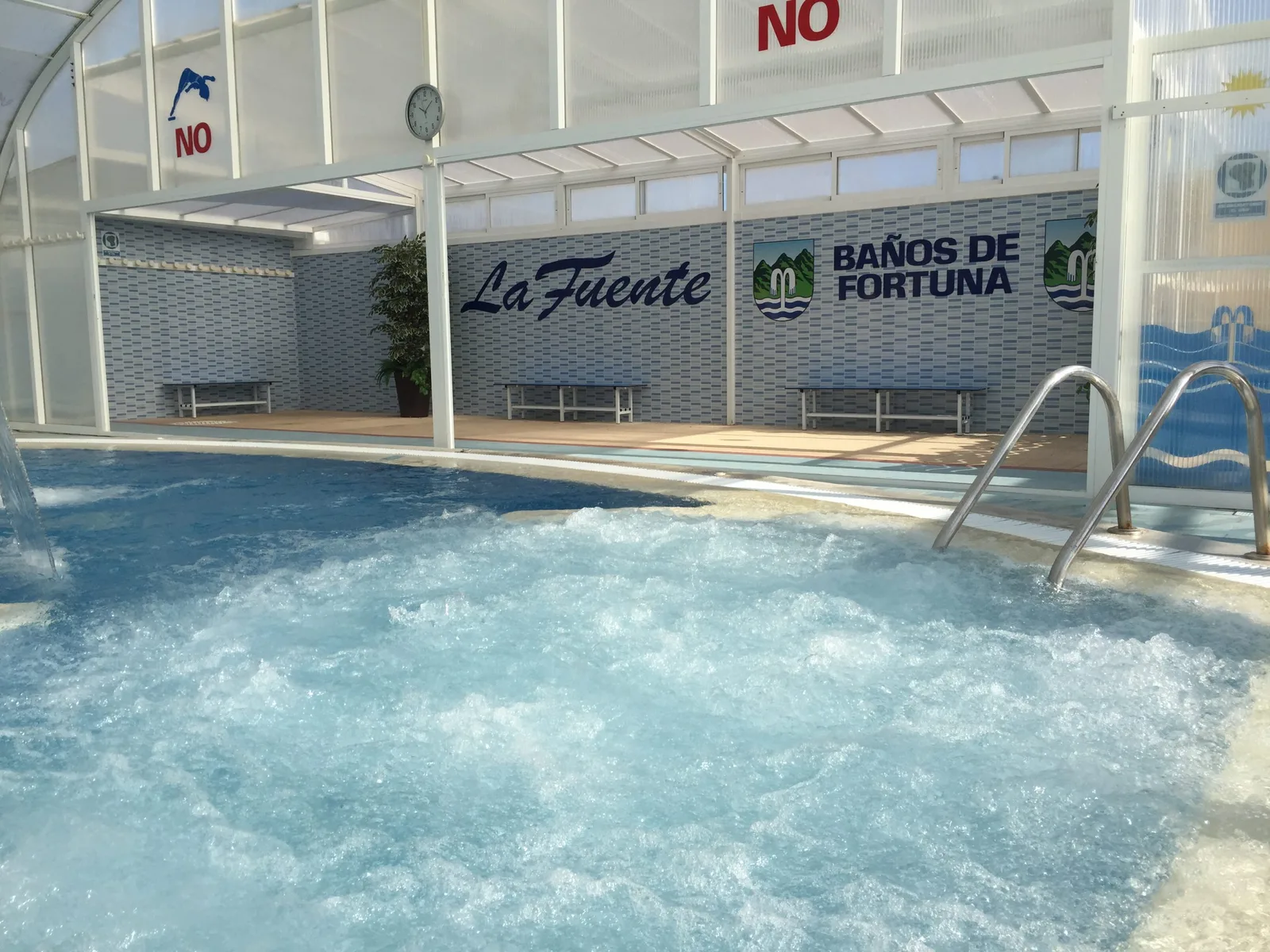 Piscina termal cubierta con zona de hidromasaje y el rótulo La Fuente Baños de Fortuna